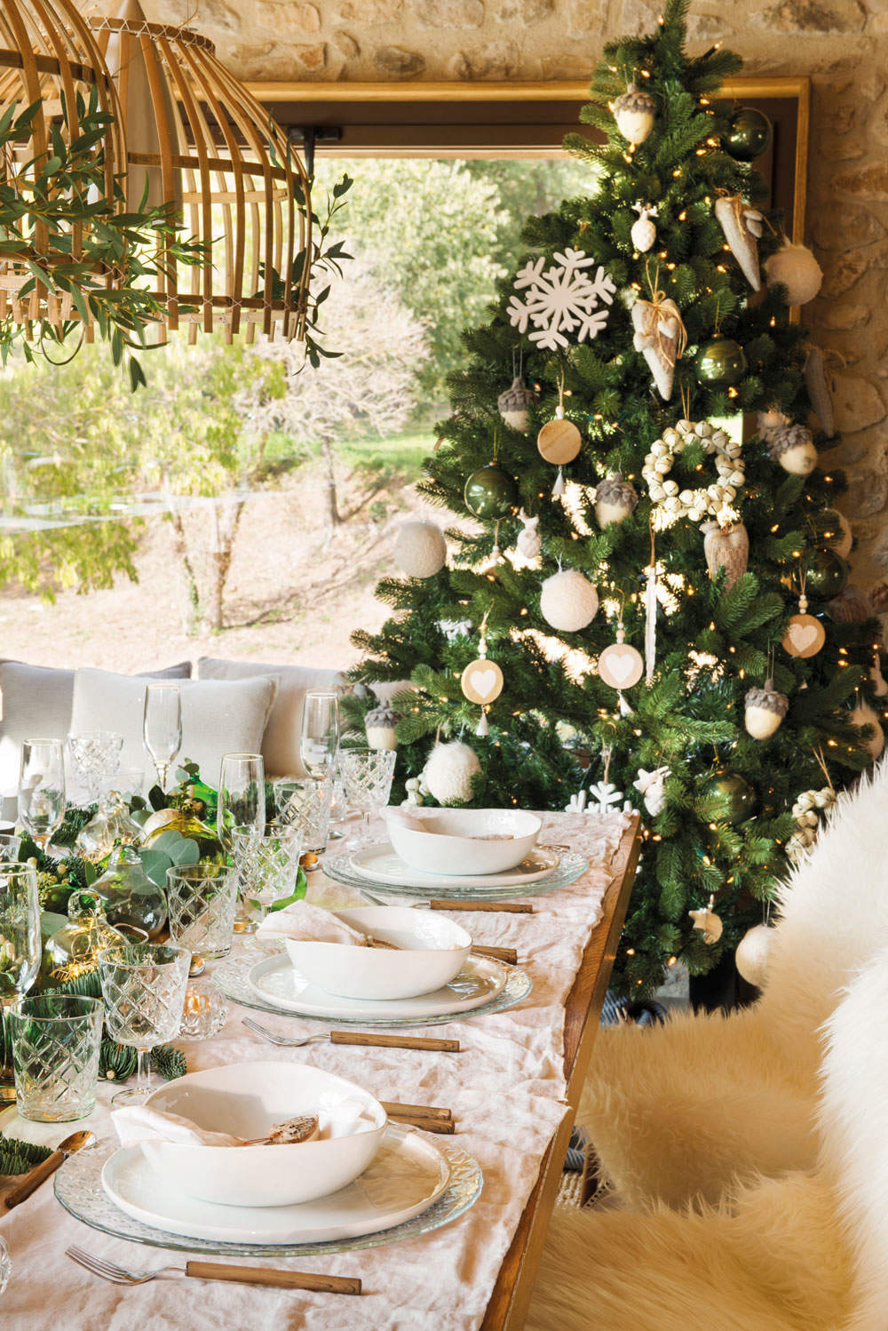 Mesa de Navidad con sillas de pelo y un árbol de Navidad con detalles blancos.