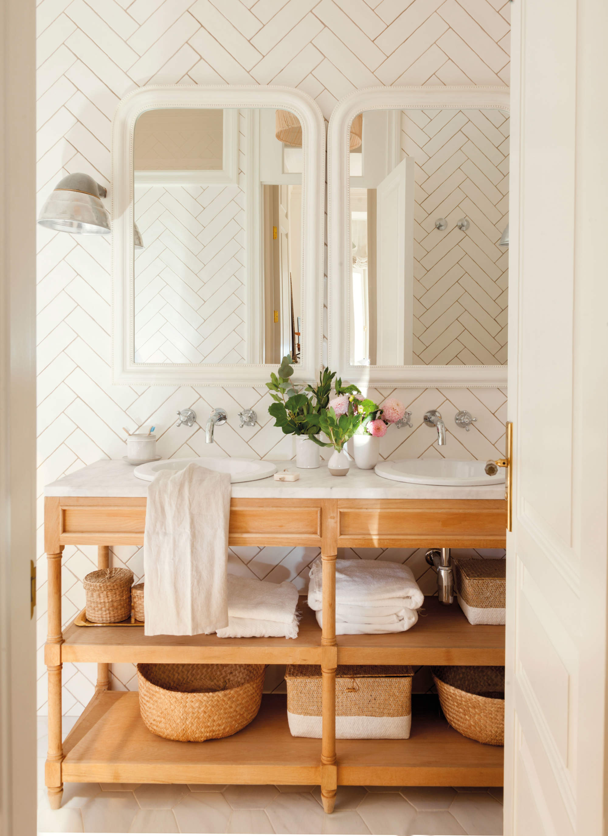 Mueble de baño abierto en madera con sobre de mármol y lavabos encastrados.